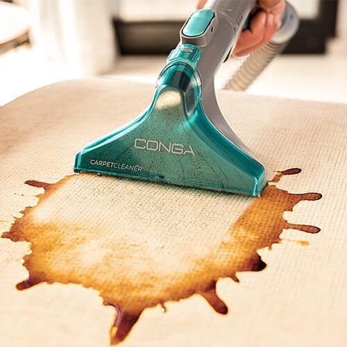 brosse de la shampouineuse Cecotec Conga 10000 CarpetClean EasyHome en train de nettoyer une tache de liquide sur un tissu clair