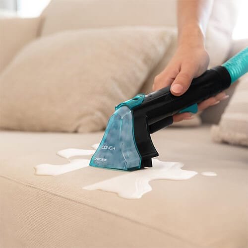 embout de la shampouineuse Cecotec Conga 2000 en action sur un canapé taché de liquide