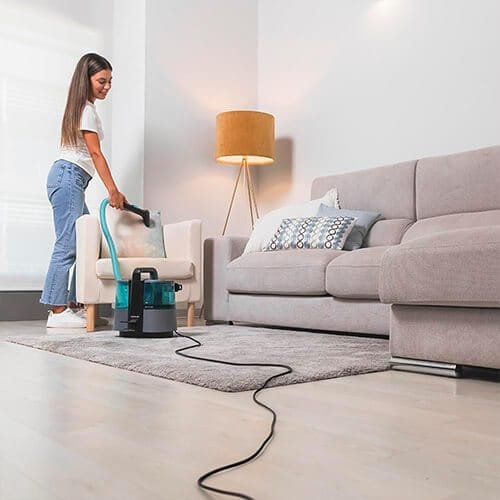 utilisation de la shampouineuse Cecotec Conga 4000 Carpet&Spot Clean XL Advance pour nettoyer un fauteuil dans un salon