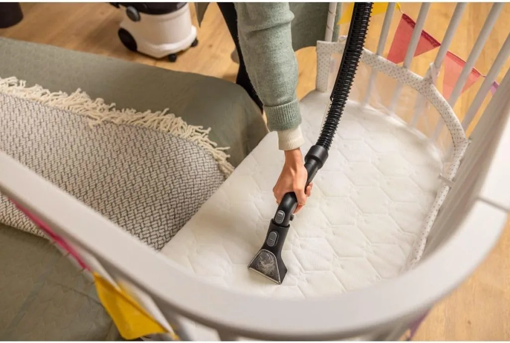 Nettoyage d’un matelas de berceau avec une shampouineuse pour garantir une hygiène parfaite dans la chambre de bébé