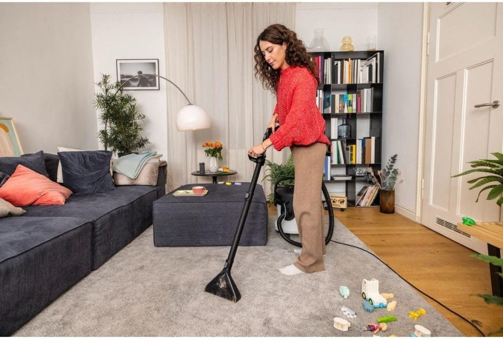 Nettoyage en profondeur d’un tapis dans un salon familial à l’aide d’une shampouineuse pour moquette
