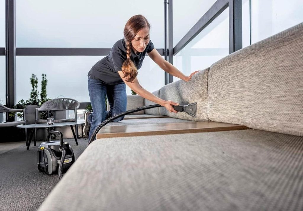 Nettoyage en profondeur d’un canapé en tissu avec la shampouineuse Kärcher Puzzi 2/1 Bp dans un espace lounge lumineux