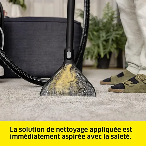 Buse de la shampouineuse Kärcher SE 4 aspirant une solution nettoyante et de la saleté sur un tapis clair