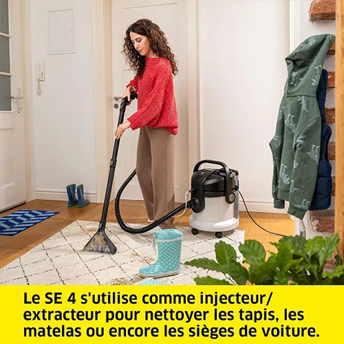 Femme utilisant la shampouineuse Kärcher SE 4 comme injecteur/extracteur pour nettoyer un tapis dans une entrée